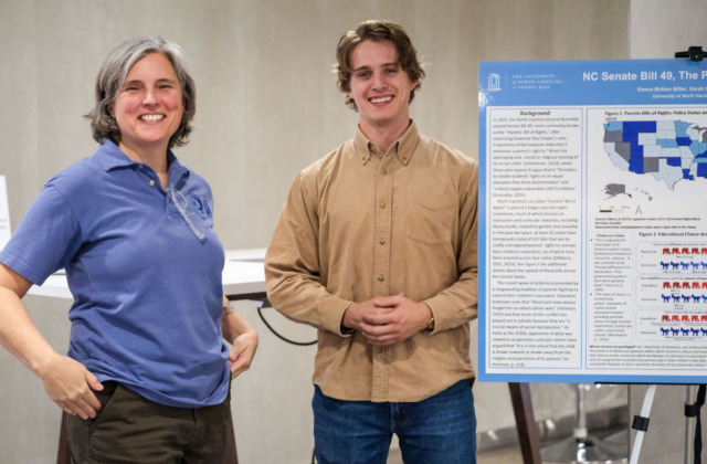 Student and faculty member pose with poster presentation