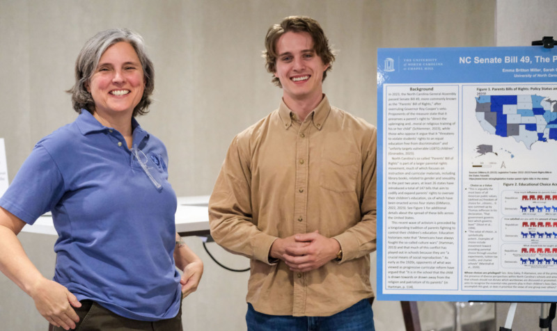 Student and faculty member pose with poster presentation