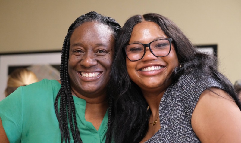 Two women pose for photo together