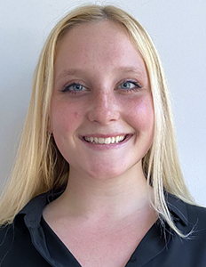 Portrait of Virginia Wood. Virginia is a white woman with straight blond hair. She is wearing a black shirt and smiling.