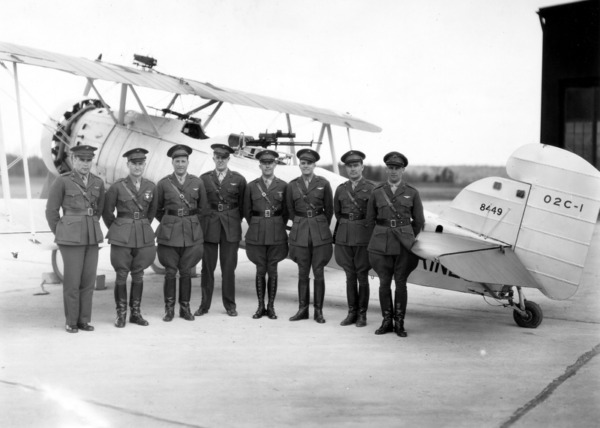 Group of Marine aviators in front of a biplane