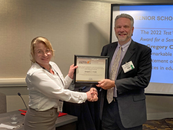 Woman handing plaque to man