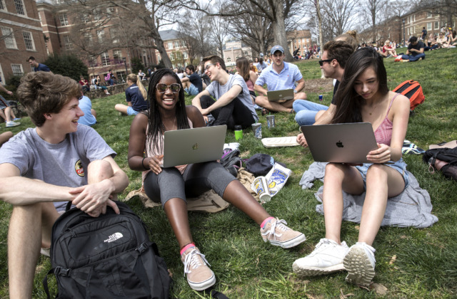 A group of students chatting while sitting on Polk Place.