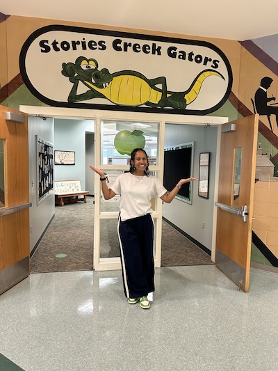 Selah Bekele-Piper standing underneath a sign that says "Stories Creek Gators."