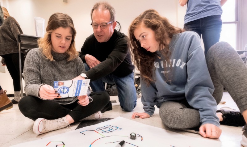 photo of UNC School of Education faculty member Keith Sawyer working with students on a coding project