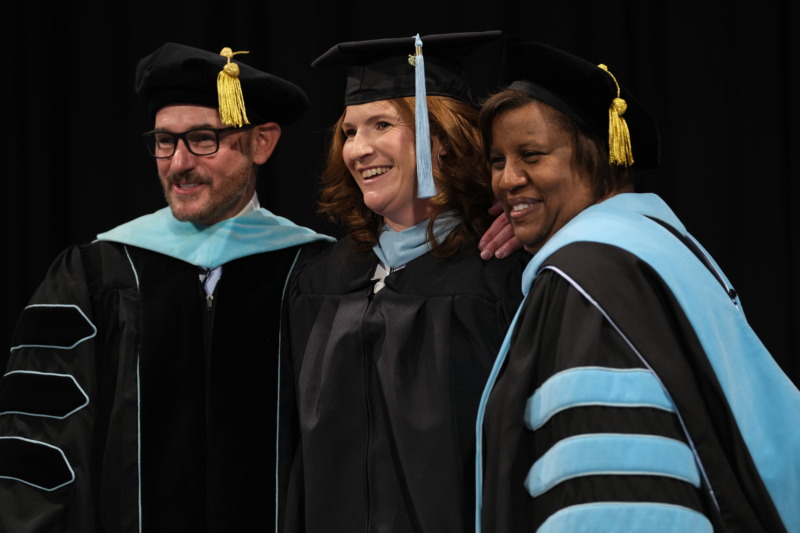 Chris Scott, Ph.D., left, Hope Heverly, center, and Martinette Horner, M.S.A. program director, pose together in academic regalia during the School's 2026 graduation ceremony.