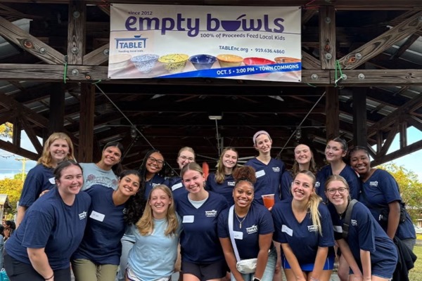 Kelly Mills, center front in light blue, volunteered with TABLE NC, helping pack and deliver healthy food to local children and families.