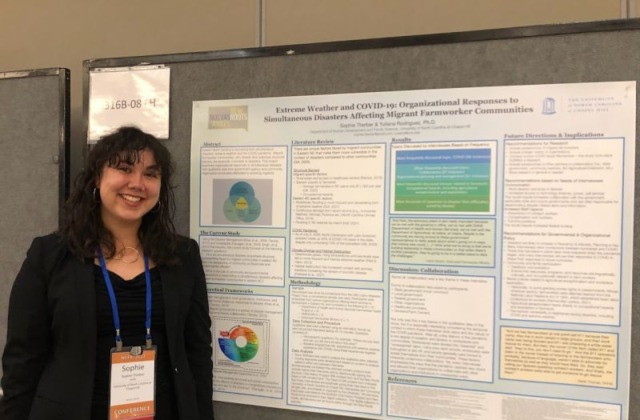 Sophie thereby posing with research poster at conference