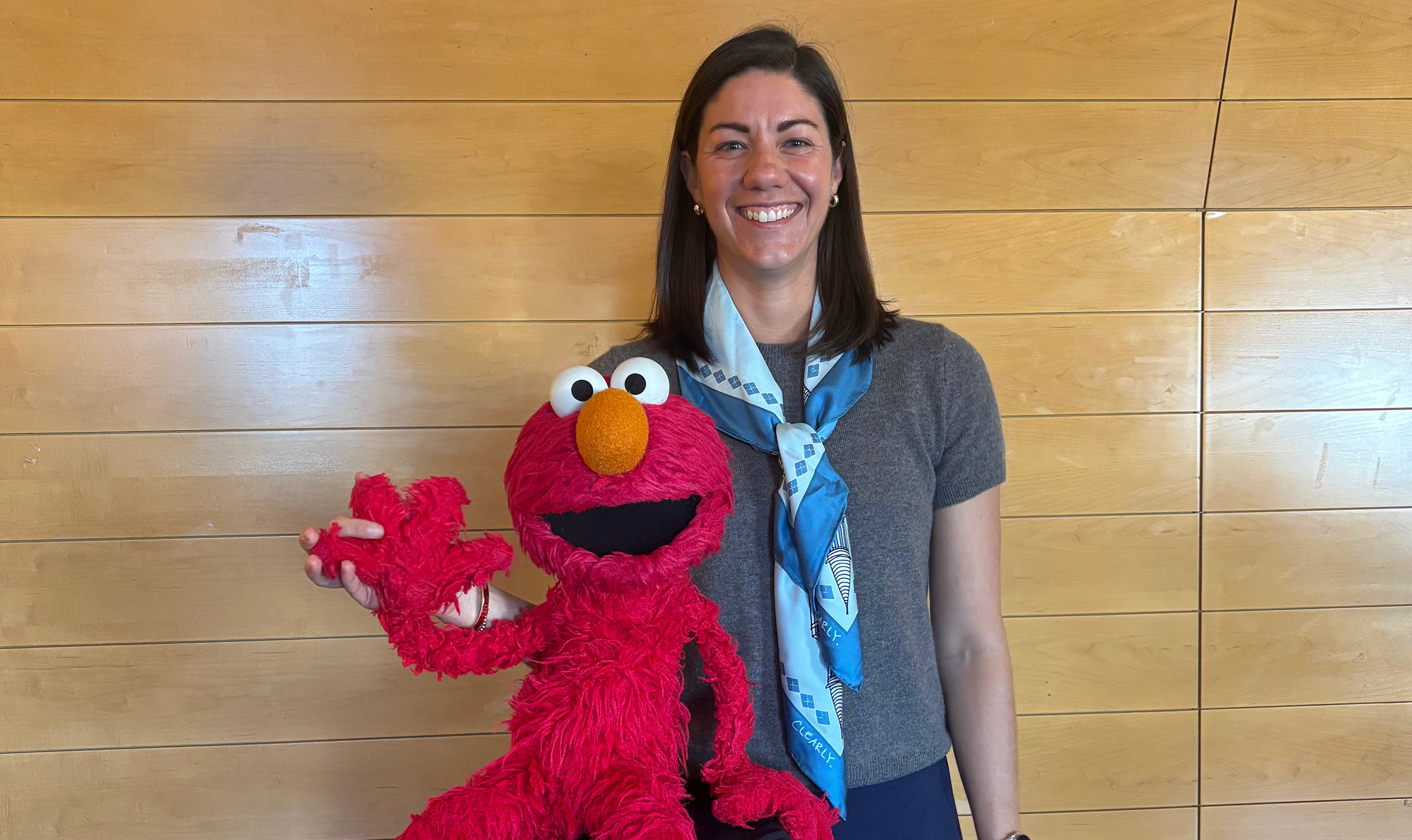 Image of Kathryn Leech with Elmo, a red-colored Muppet that appears on Sesame Street