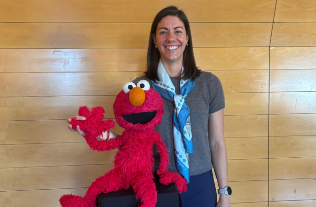 Image of Kathryn Leech with Elmo, a red-colored Muppet that appears on Sesame Street