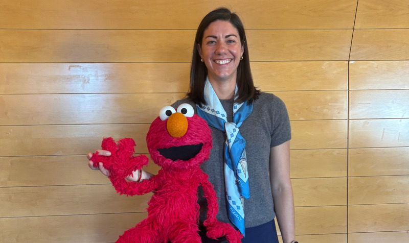 Image of Kathryn Leech with Elmo, a red-colored Muppet that appears on Sesame Street