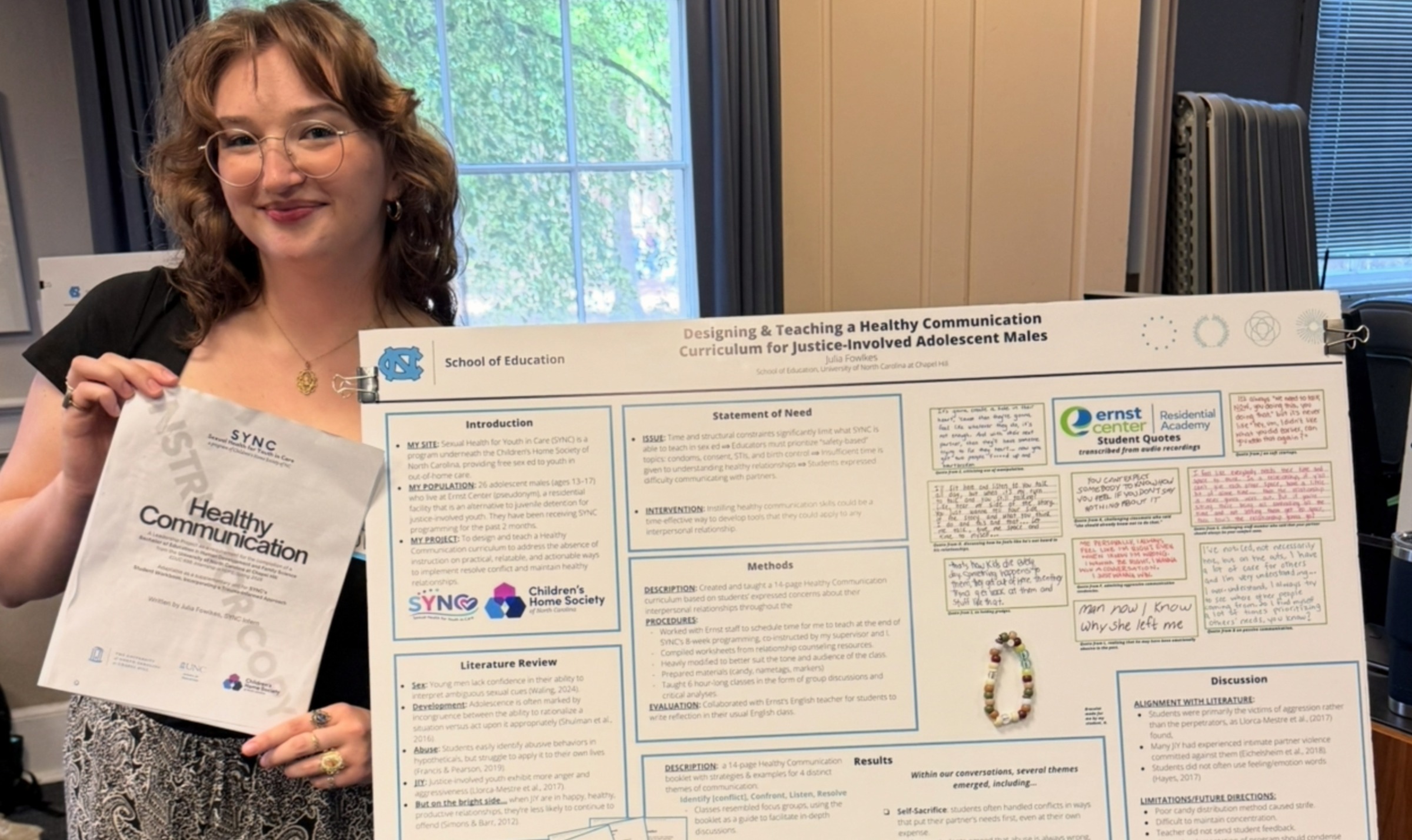 Julia Fowlkes ('26 B.A.Ed.) poses with her search poster titled 