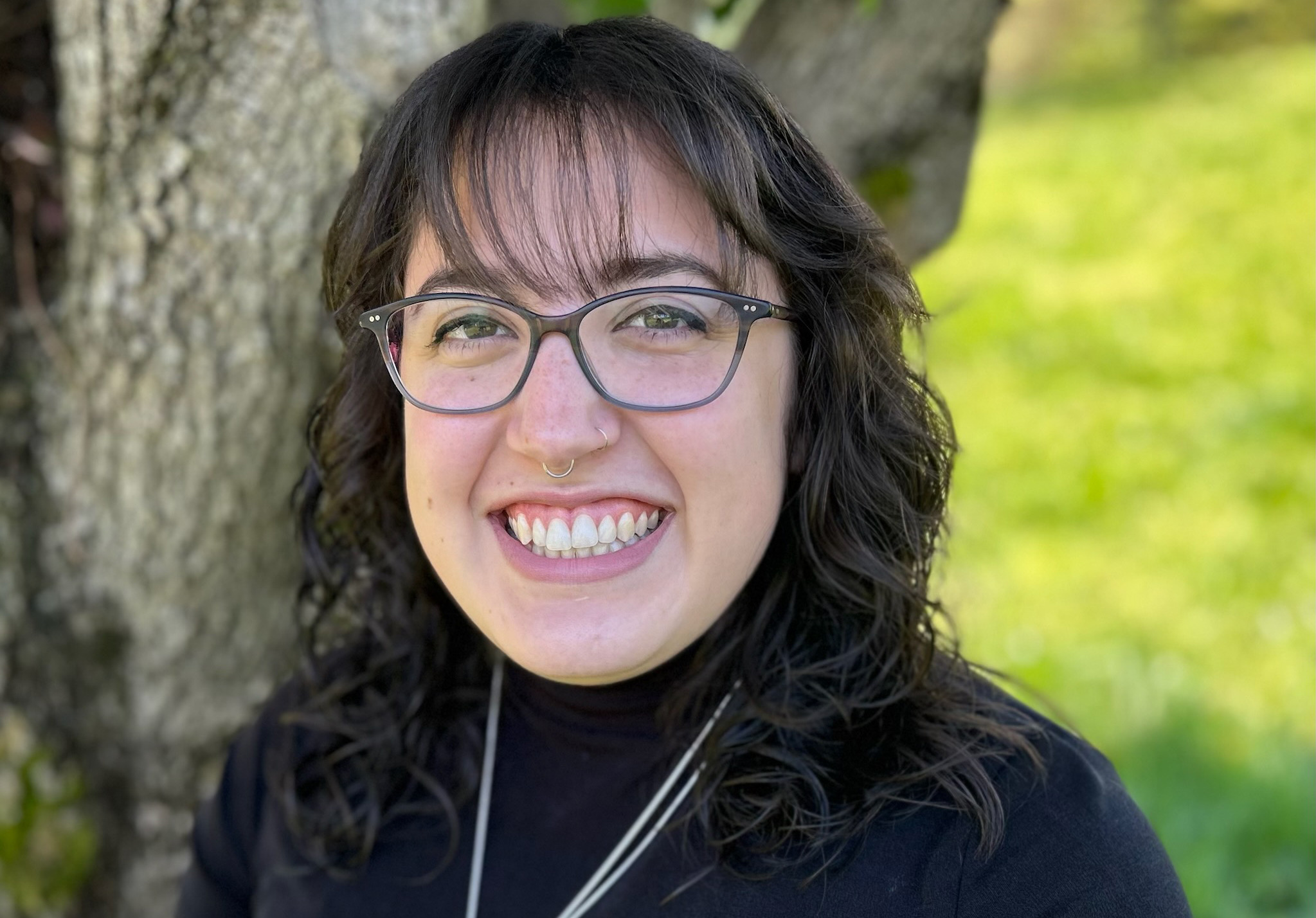 Image of Courtney Medina outside standing next to a tree