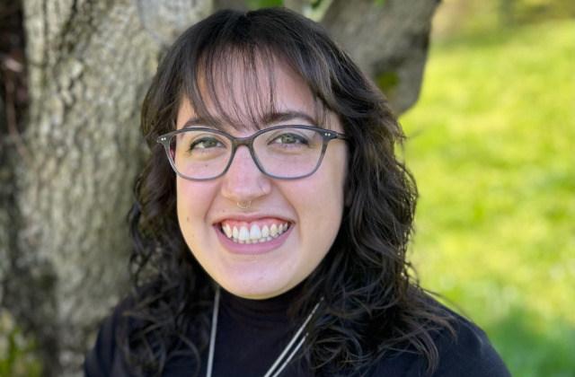 Image of Courtney Medina outside standing next to a tree